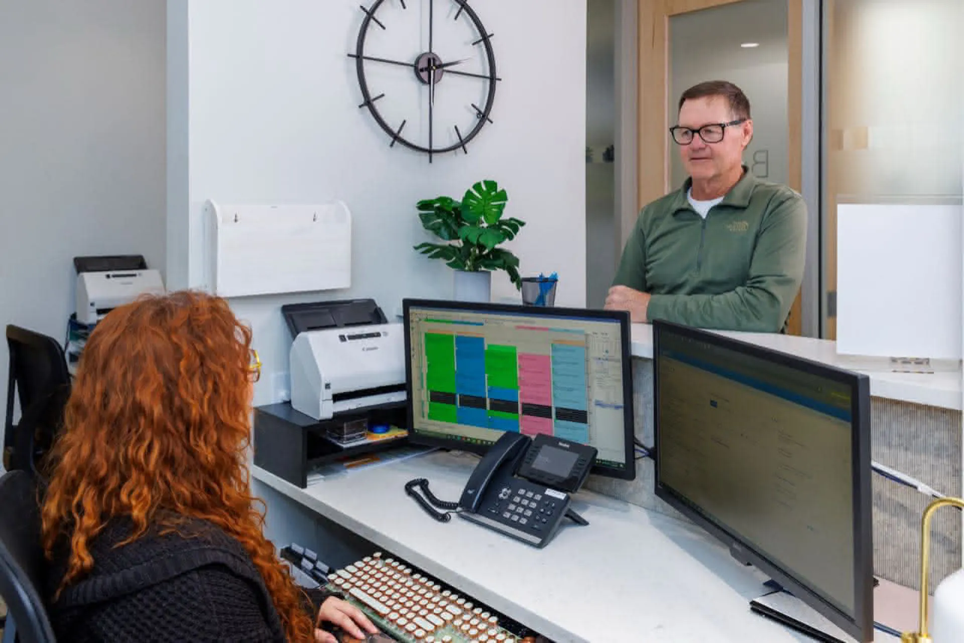 Front desk with patient speaking to staff