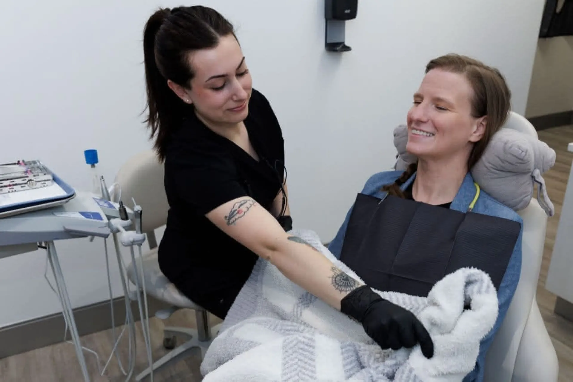 Staff member adjusting a blanket on a patient
