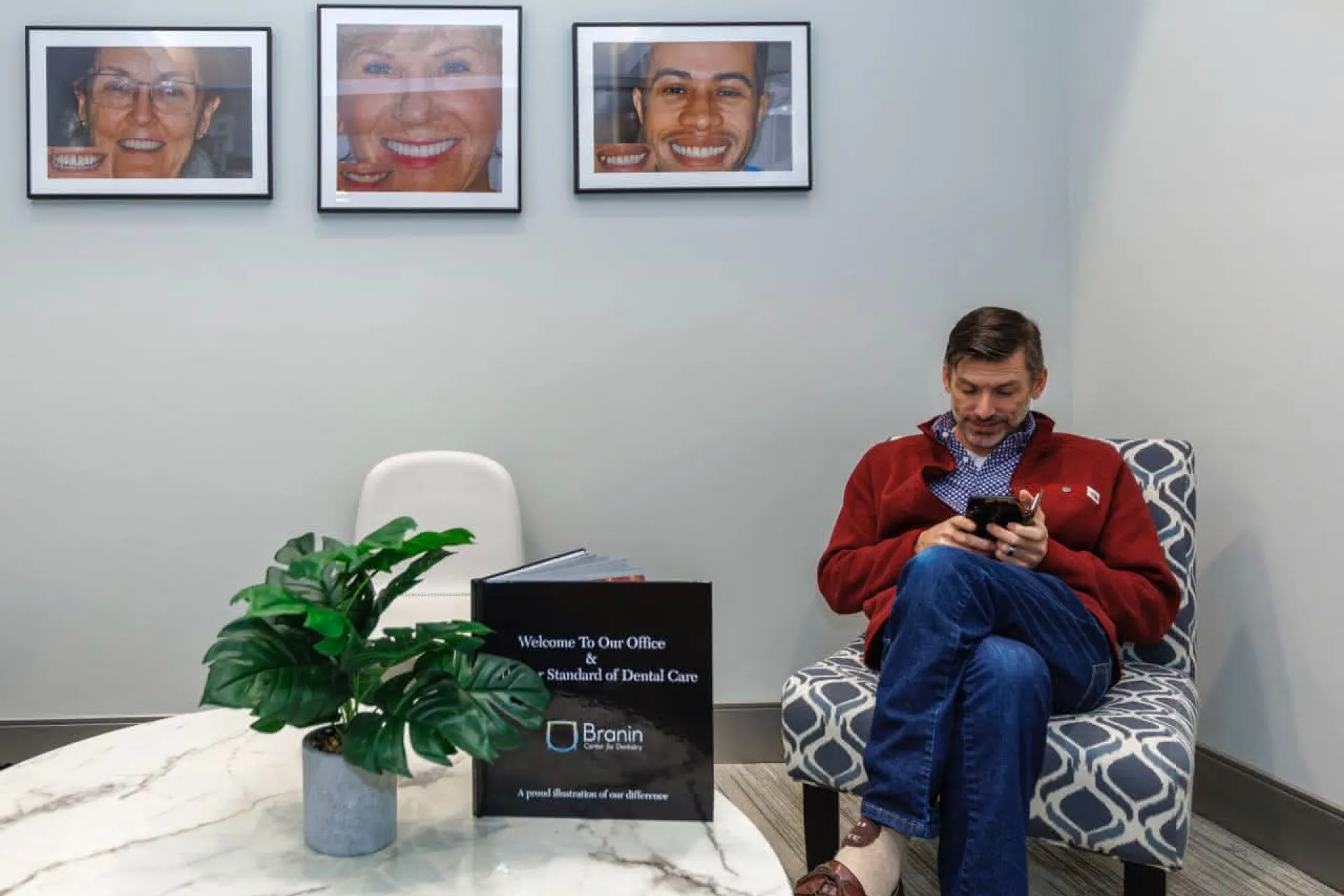 A patient in a chair in the lobby looking at a phone