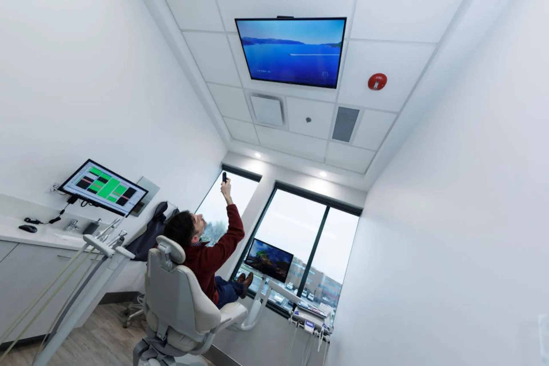 A patient in a chair looking at a monitor on the ceiling
