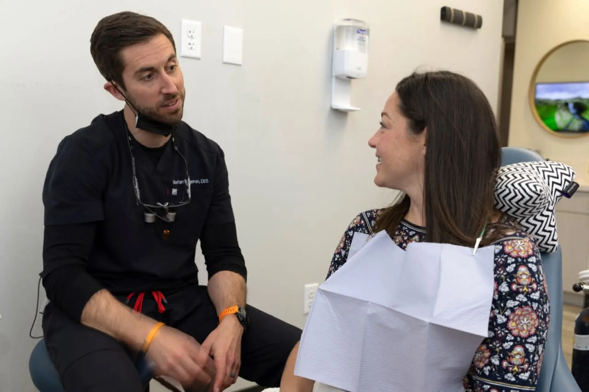Dentist sitting with patient discussing procedures